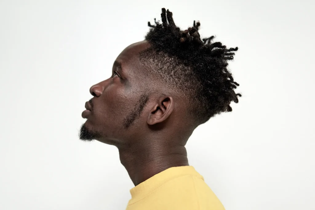 Mr Eazi, Nigerian music star and one of the richest musicians, standing in a vibrant Japanese city street.